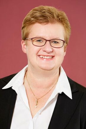 Petra Mollenhauer blickt direkt in die Kamera und zeigt ein freundliches Lächeln.