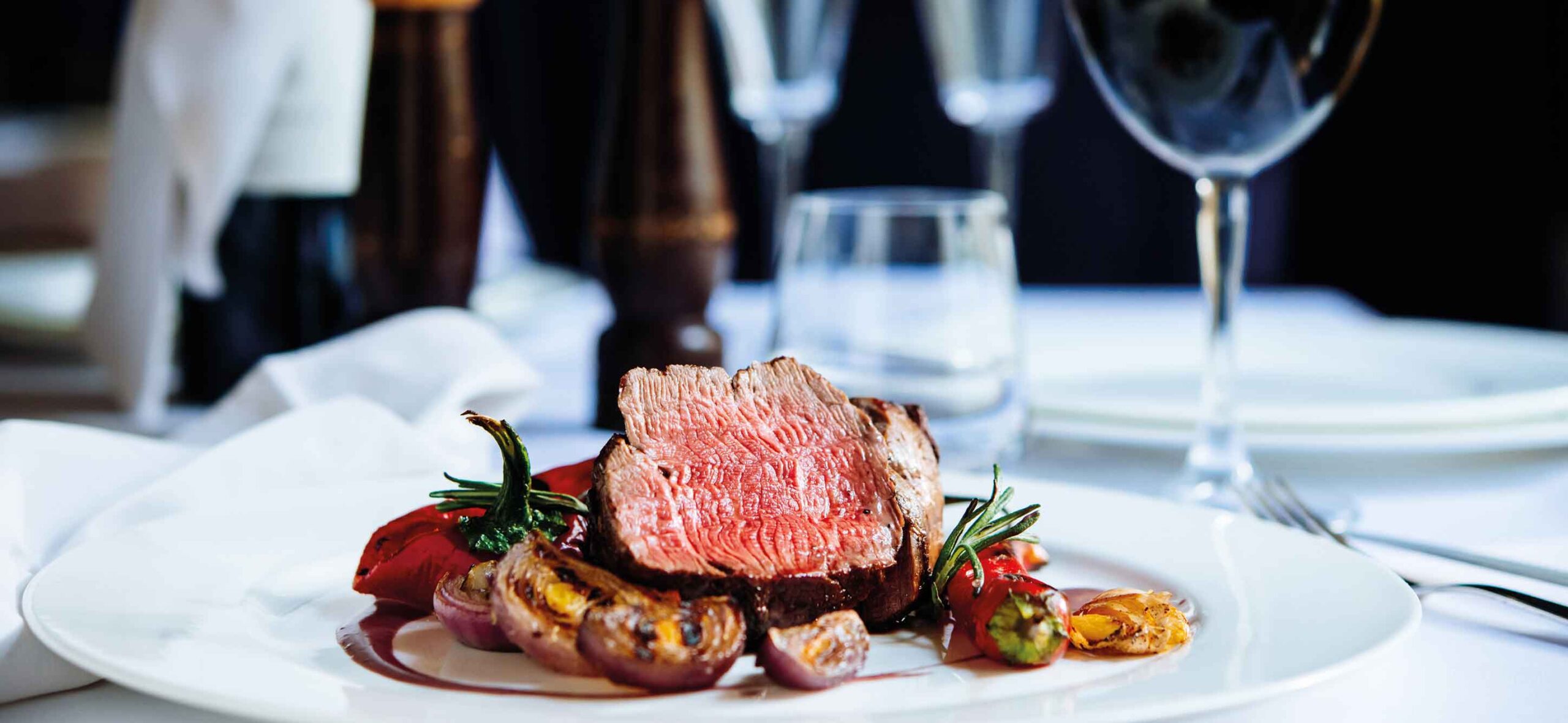 Ansprechend angerichteter Teller mit einem Fleischgericht, serviert in einem stilvollen Restaurantambiente.